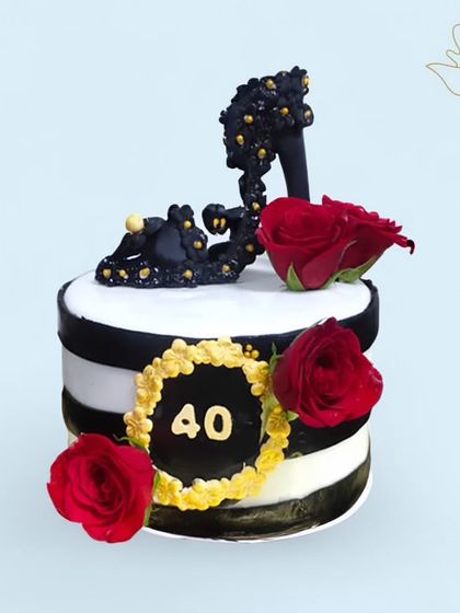 A glamorous cake for a fashionista turning 40. This design features a stylish black high heel, red roses, and a chic black and white striped pattern.