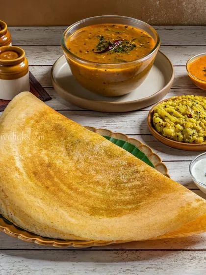 A classic Masala Dosa from Gulab Sweets, folded into a triangle and served with traditional sides.