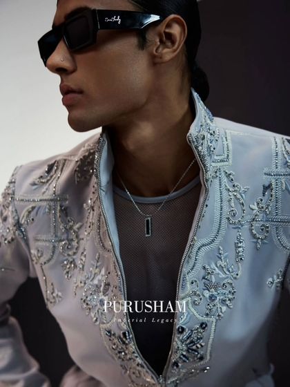 A close-up on the light grey bomber. The detailed beadwork and embroidery catch the light beautifully, while the modern sunglasses complete this effortlessly cool look.