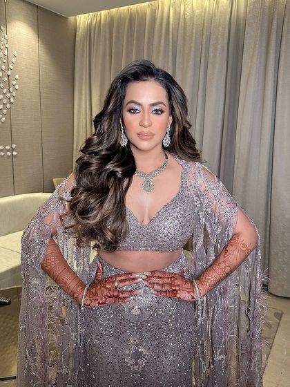 The bride striking a powerful pose, her voluminous curls adding to the drama and glamour of her cocktail look.