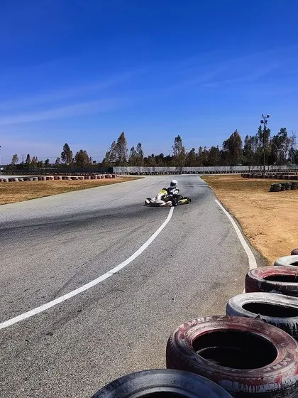 A driver on track during a pre-season test under a clear blue sky.