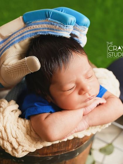 Dreaming of future centuries. This cricket-themed newborn shoot is a wonderfully personal way to celebrate a family's passion, with the baby sleeping soundly in a bucket, protected by a batting glove.