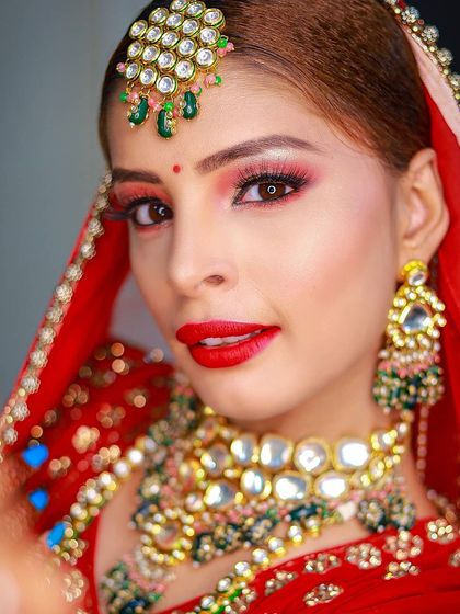 A close-up beauty shot that highlights the bride's bold red lipstick and flawless makeup.