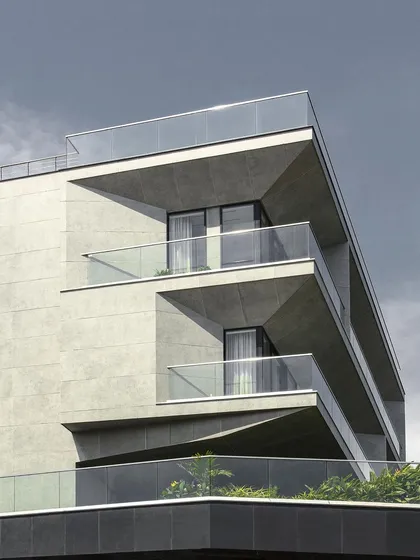 A detail of the facade at Villa Vue in Visakhapatnam. The tapered apertures and deep-set balconies are designed to frame panoramic views of the sea while providing shade and privacy. The concrete finish gives the building a monolithic and sculptural quality.