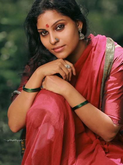 A rustic, village-themed series inspired by the movie 'Kanthara'. The model is styled in a simple red saree, captured in a natural, watery landscape to evoke a sense of raw, earthy beauty.