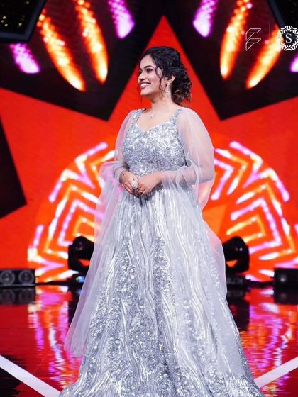 Sayli Kamble shines on stage in our sequined silver gown. The delicate puff sleeves add a touch of modern elegance to this glamorous outfit.