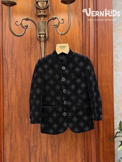 This black patterned Jodhpuri jacket offers a subtle yet stylish look. It’s a perfect example of how we blend classic silhouettes with unique fabrics to create outfits fit for a little prince.