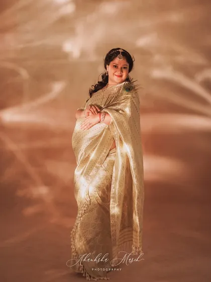 A full-length portrait using creative lighting to cast a beautiful, artistic pattern on this mother-to-be in her golden saree.