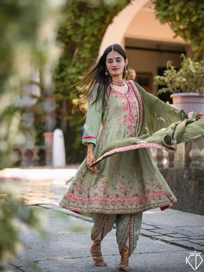 A dynamic shot of the bride twirling, her Anarkali suit and dupatta creating beautiful movement.