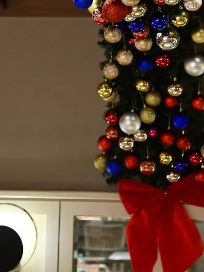 A close-up of a Christmas garland, finished with a large red bow. It's a classic touch that instantly says 'festive'.
