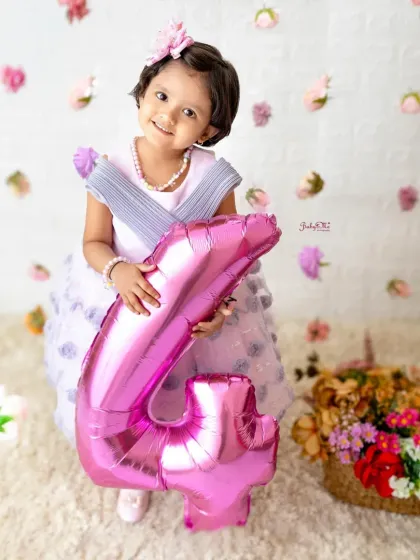 A big number four balloon for the birthday girl. The falling flower petals add a touch of magic to this sweet fourth birthday portrait.