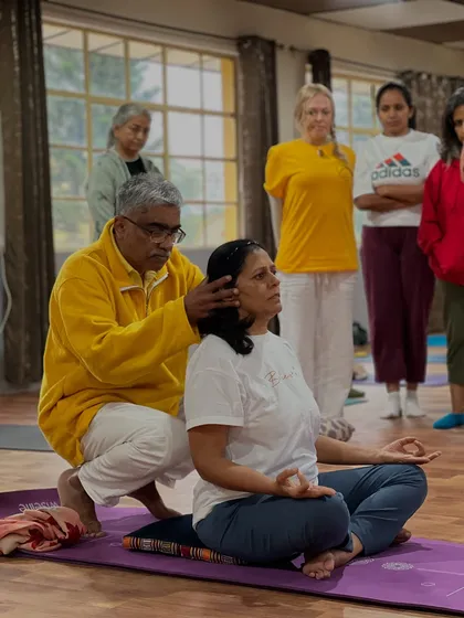A teacher's gentle guidance can make all the difference. Here, I am helping a student find the correct alignment in a seated meditation posture, ensuring the spine is erect for the free flow of *prana*.