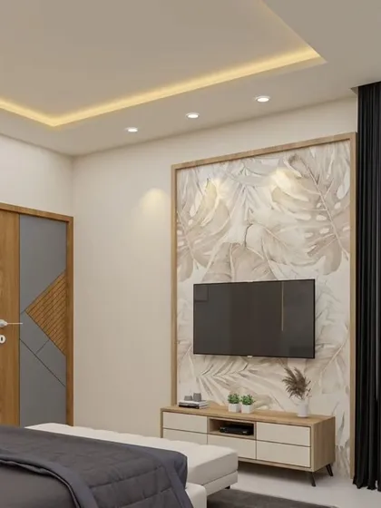 This bedroom TV unit is framed by a soft, leaf-patterned wallpaper and a simple wooden border. The clean, white floating console offers storage while maintaining a light and natural aesthetic.