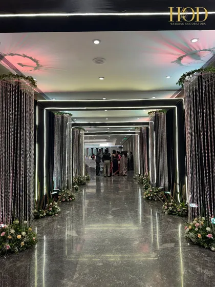 The crystal curtain hallway illuminated with bright white light, creating a sleek and sophisticated entrance for a modern wedding reception.