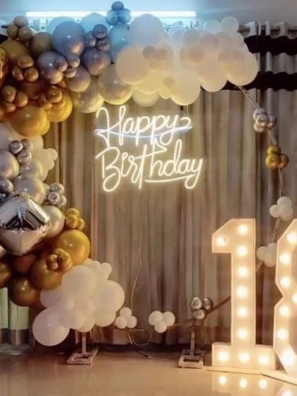 An 18th birthday party with a "heaven" theme, using white, gold, and silver balloons to create clouds.