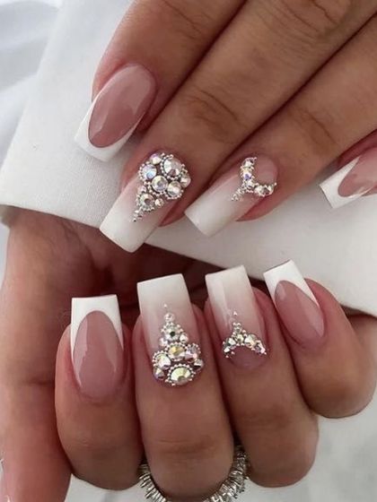 Nail inspiration for bridal or festive nails, combining a French manicure with elaborate, clustered rhinestone art.