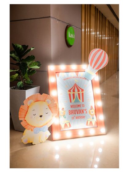 A light-up welcome sign for Bhuvan's 1st birthday, designed with a cute circus theme featuring a lion and a hot air balloon.