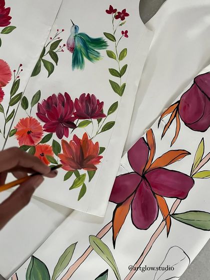Another angle of me painting florals on fabric. You can see the different styles I can create, from the detailed hummingbird and flowers on the left to the bolder, outlined flowers on the right.