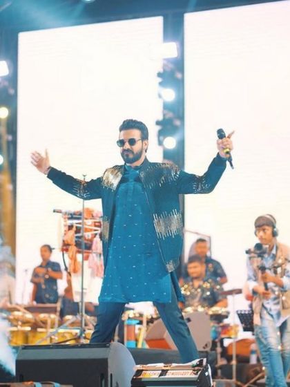 Commanding the stage in bespoke style. This image captures the energy of a live performance, with the artist wearing our custom-designed jacket and kurta set.