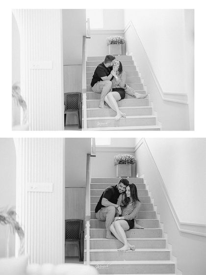 A candid black and white photo capturing a quiet, romantic moment on the stairs during their at-home pre-wedding session.