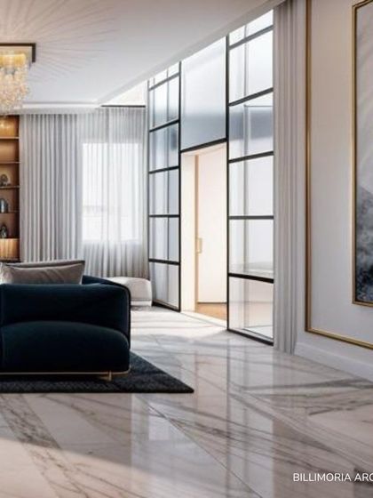 A modern glass and metal partition elegantly divides the space without obstructing light or views. This feature, paired with a grand crystal chandelier and abstract art, adds a layer of architectural interest to the luxurious living room.