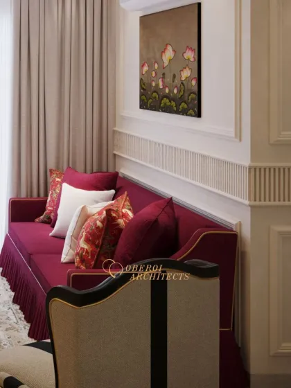 A detail of the custom-designed sofa with its deep red upholstery and pleated skirt, showcasing our attention to fine tailoring and traditional furniture craftsmanship.