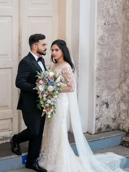 A stylish pose outside the church. The groom's sharp tuxedo and clean haircut create a sophisticated silhouette.