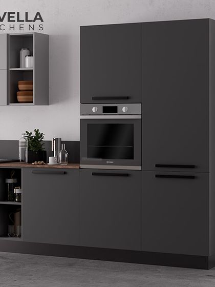 This image highlights a tall unit in a dark matte finish with an integrated oven. The handleless design and monochromatic color scheme are hallmarks of our sleek, German-style modular kitchens.