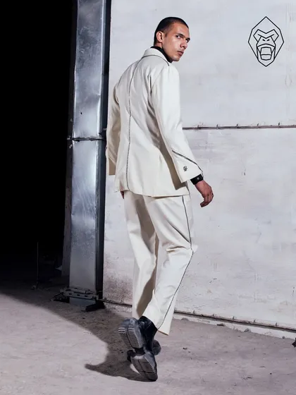 The back view of the Ivory Industrial suit, showing the clean lines and contrast piping that define its structure. This is a suit built for making an entrance and an exit.