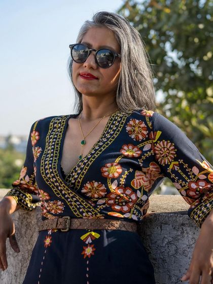Another shot of the floral jumpsuit, showing how the sunglasses and red lipstick add a touch of glamour to the look.