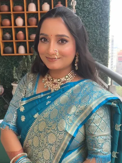 A dreamy and soft glam look for an engagement ceremony. The makeup complements her beautiful blue saree, with a focus on radiant skin and softly defined eyes.