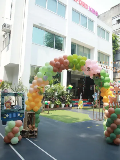 A balloon arch for a Madagascar-themed party, featuring cute deer and lion cutouts.