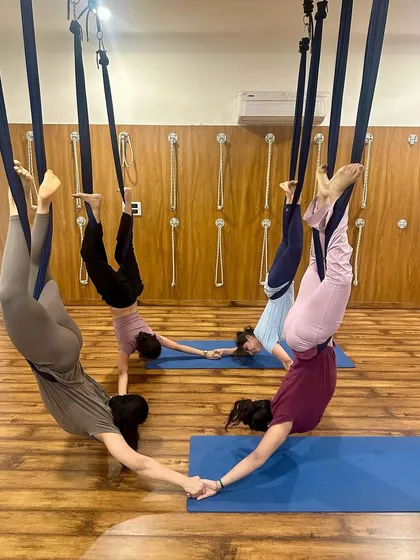 Our students working together in a synchronized aerial yoga pose, creating a beautiful shape while building community and trust.