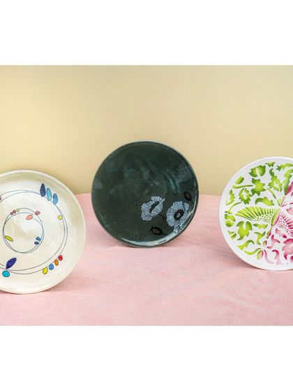 A simple, clean shot of three different hand-painted plates lined up. This is a great way to compare different designs in a collection.