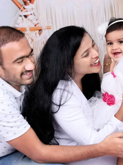Pure bliss. This candid shot captures the laughter and love between parents and their baby girl, all dressed in white for a clean and bright family portrait.