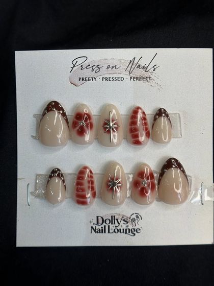 A beautiful festive press-on set with delicate silver bows and red plaid-inspired patterns on a sheer, shimmery base.