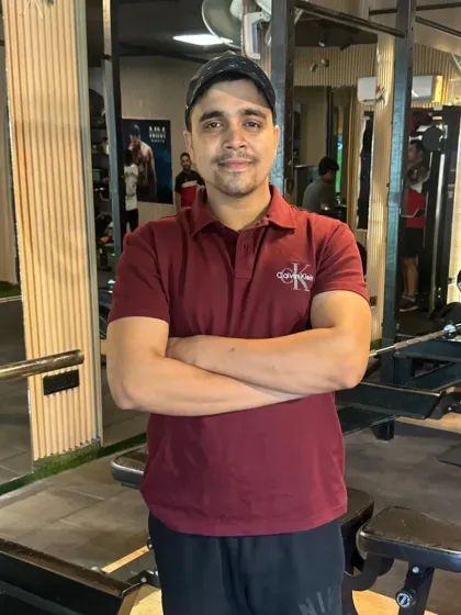 Arms crossed, showing a confident and approachable coaching style.