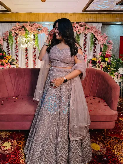A happy client in a beautiful lavender-grey lehenga with silver and blue embroidery. This is a perfect example of a modern, elegant outfit for a wedding guest.