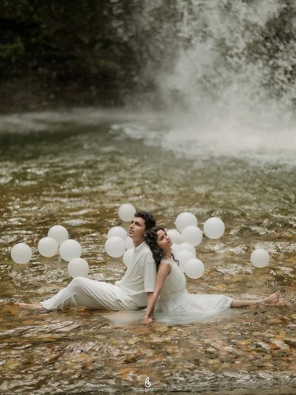 A serene moment, sitting back-to-back in the water, looking up at the sky. This is a unique and contemplative couple portrait.
