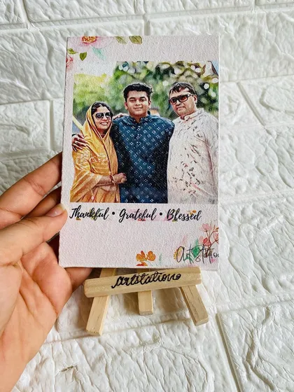 Holding the mini illustrated canvas to show its size. It's a perfect, compact gift that can fit anywhere, constantly reminding your loved ones of a special moment.