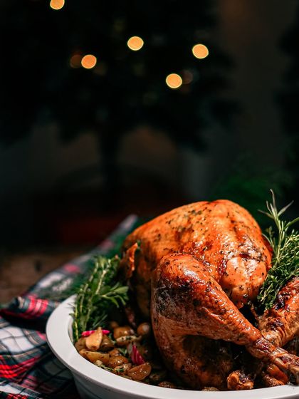 A stunning shot of our whole roast turkey against a festive, bokeh background. This image perfectly captures the magic and warmth of a holiday feast.