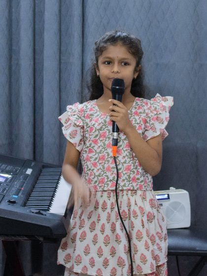 A young vocalist performing at the BEML branch open mic. I ensure a supportive atmosphere where every student feels comfortable on stage.