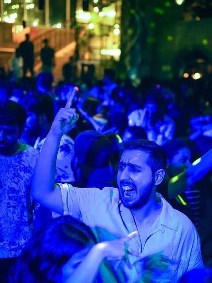 A partygoer completely immersed in the music under the blue lights at Social. These are the moments of pure energy I strive to create.