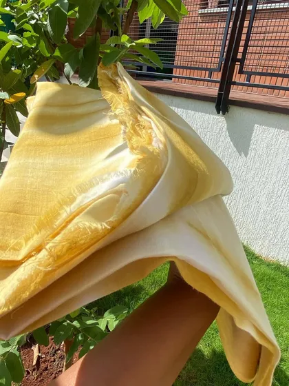 The light catching the delicate, translucent quality of the cotton voile. Natural dyeing enhances the inherent beauty of the fabric.