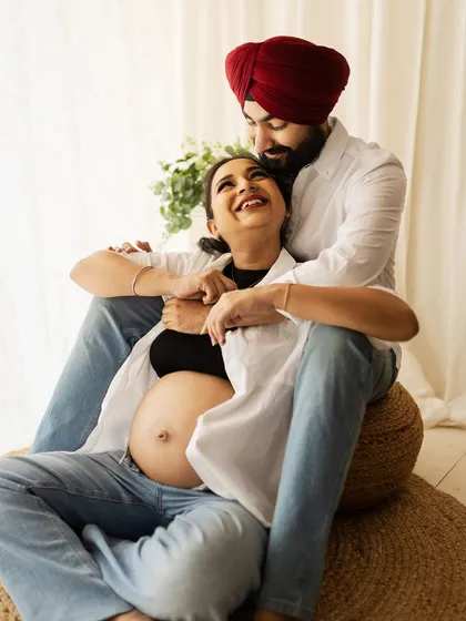 A tender and joyful moment from a lifestyle maternity shoot. The couple's laughter and loving embrace perfectly capture the excitement of this special time.