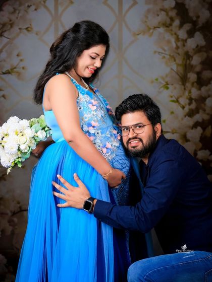 A sweet and classic pose. The dad-to-be kneels to listen to the baby bump, sharing a special moment with his partner and their unborn child.