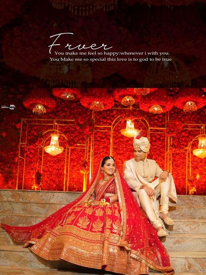 A regal portrait of the couple seated on steps, with the bride's red lehenga spread out beautifully. The text overlay adds a touch of romance to this grand photo.