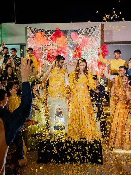 A moment of pure celebration! The couple being showered with flower petals during their Haldi ceremony.