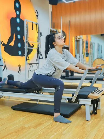A client performs a deep lunge stretch on the reformer, a fantastic exercise for improving hip flexibility and releasing tension.