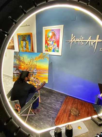 A creative shot of me working in the studio, framed by a ring light. This perspective shows the intersection of modern tools and traditional art forms in my daily process.